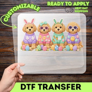 May include: DTF transfer featuring four cartoon dogs dressed for Easter. Each dog wears a sweater and bunny ears or sunglasses. Colorful Easter eggs are at the dogs' feet. The words "CUSTOMIZABLE" and "READY TO APPLY" are visible.
