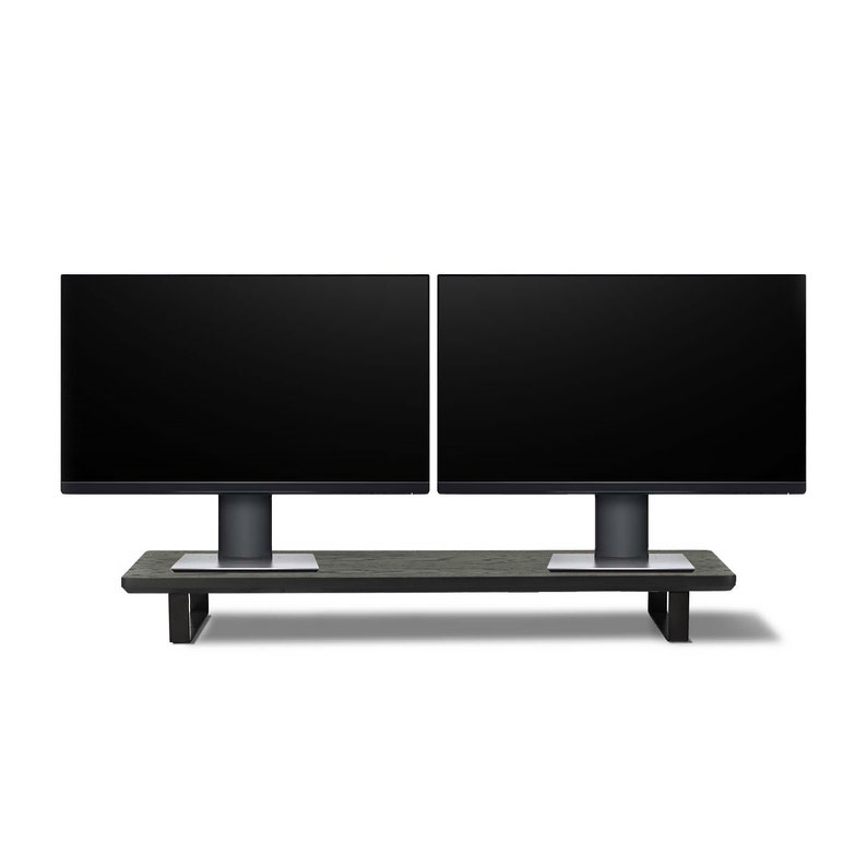 Pu&ograve; includere: Due monitor per computer neri sono montati su un supporto in legno nero. I monitor sono posizionati uno accanto all'altro e hanno un design elegante e moderno.