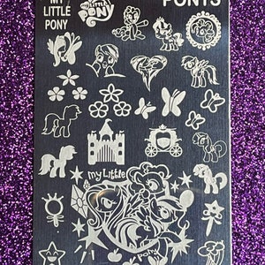 May include: A silver nail art stamping plate with the words "My Little Pony" and "Ponys" at the top. The plate features a variety of images, including ponies, butterflies, flowers, a castle, a carriage, and stars.