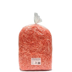 Op de afbeelding: Een grote, doorzichtige plastic zak gevuld met perzikkleurige crinkle papiersnippers. De zak is aan de bovenkant verzegeld. Het etiket luidt "Crinkle Paper Shreds" en "1kg Peach".