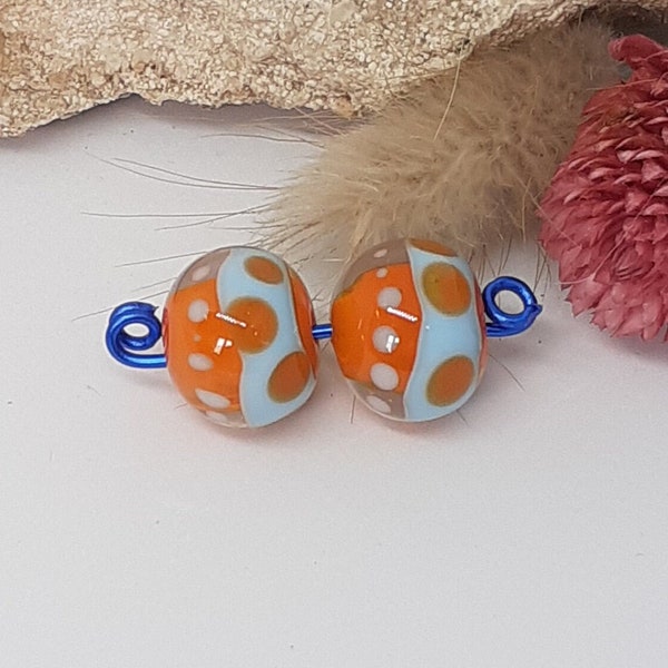 Deux perles de verre filées à la flamme, orange, bleu clair, blanc et transparent