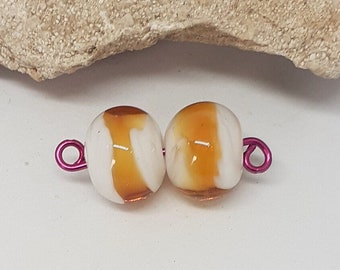 Deux perles de verre filées au chalumeau, blanc, transparent et couleur ambre