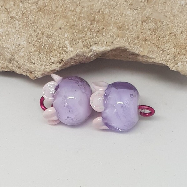 Deux perles de verre, rose clair et violet transparent