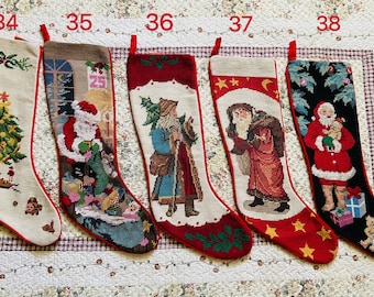 Pode incluir: Cinco meias de Natal com designs festivos. Cada meia apresenta uma ilustração única em estilo tapeçaria, incluindo o Pai Natal, árvores de Natal e cenas de férias. As meias têm acabamentos vermelhos e laços para pendurar.