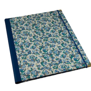 Puede incluir: Una carpeta con estampado azul y blanco, con encuadernación azul y cierre elástico azul.