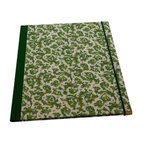May include: A rectangular portfolio folder featuring a cream-colored cover with a repeating green and brown leafy scrollwork pattern. The folder has a solid dark green spine and a thin dark green elastic band closure running vertically.