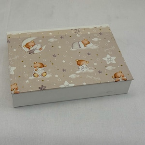 May include: A rectangular white box with a beige lid featuring a repeating pattern of brown teddy bears, white clouds, and stars. The bears are depicted in various sleeping positions, and the text "good night" is printed in a cursive script.