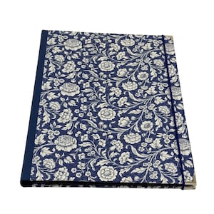 Peut inclure: Un porte-documents rectangulaire présentant un motif floral bleu foncé et blanc sur la couverture avant. Le dossier possède une tranche bleu foncé unie et une fine bande élastique bleu foncé qui s'étire verticalement sur le côté droit.