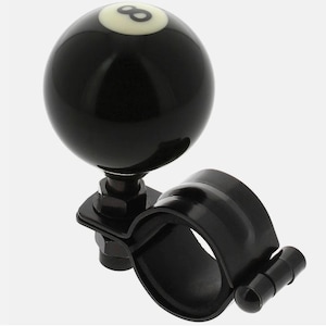 May include: Black steering wheel spinner with a glossy black 8-ball design and white number 8. The spinner has a black mounting bracket and a circular handle. This accessory is designed for vehicle steering wheels.