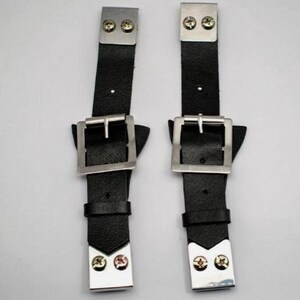 May include: A pair of black leather straps with silver metal buckles and rivets. Each strap features a rectangular buckle and is secured with two screws at each end. These straps are designed for fastening or adjustment.