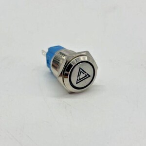 May include: A silver metal push button with a blue base. The button has a black triangle symbol within a circle. The button is designed for electrical applications.