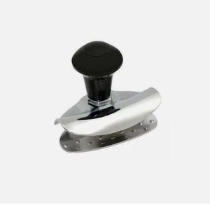 May include: A silver-coloured, hand-held kitchen tool with a black handle. The tool has a curved, blade-like design and a perforated base. The handle is round and sits atop a hexagonal base. The tool is designed for kitchen use.