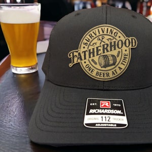Surviving Fatherhood Leather Patch Hat | Funny Beer Drinking Custom Trucker Hat | Gift For Him Unique | Richardson 112 or Flexfit Hat