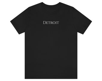 May include: A black t-shirt with the word "DETROIT" printed in white on the front.