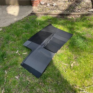 K&ouml;nnte beinhalten: Eine schwarze Autoteppichmatte mit verschiedenen Schwarzt&ouml;nen. Die Matte besteht aus einem weichen, pl&uuml;schigen Material und ist dazu bestimmt, den Boden eines Fahrzeugs zu sch&uuml;tzen.