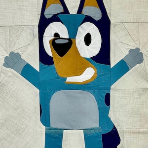 May include: A blue, gray, and white patchwork dog with a brown nose and black eyes. The dog is standing with its arms outstretched.