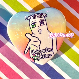 May include: A heart-shaped button with a rainbow gradient background. The button features a cartoon character with the text "Let's take ibuprofen together" and the word "celchuno!" in a glittery font.
