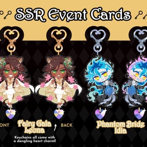 May include: Four colorful keychains featuring anime characters from the game Twisted Wonderland. The keychains are designed with a front and back side. The front side features a character from the game, and the back side features a heart-shaped charm. The keychains are labeled with the character's name and the event they are from. The keychains are labeled "Fairy Gala Leona" and "Phantom Bride Idia".