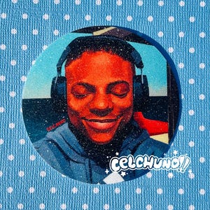 May include: A round, glittery image featuring a person wearing headphones, with eyes closed and a smile. The image has a blue and white background with the text "CELCHUNO!!" and "CELAUNG" in white. The person is wearing a blue hoodie.
