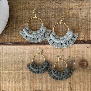 May include: Two pairs of hoop earrings with fringe. The top pair is light gray and the bottom pair is dark gray.