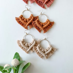 May include: Three pairs of handmade macrame earrings with gold hoops. The earrings are in three colors: terracotta, brown, and cream.