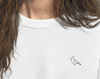 May include: A white crewneck sweatshirt with a small, embroidered outline of a bird on the front.