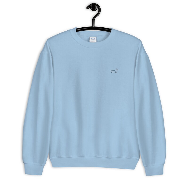 May include: A light blue sweatshirt with a small embroidered dachshund on the front.