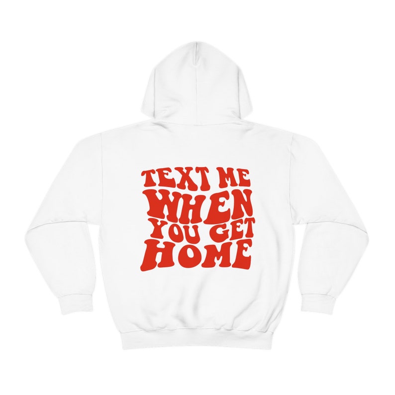 K&ouml;nnte beinhalten: Wei&szlig;er Kapuzenpullover mit dem Text "TEXT ME WHEN YOU GET HOME" in roten, retro-artigen Buchstaben.