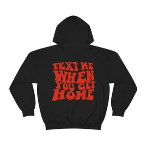K&ouml;nnte beinhalten: Schwarzer Kapuzenpullover mit rotem Text, der "Text Me When You Get Home" in einer Retro-Schriftart lautet.