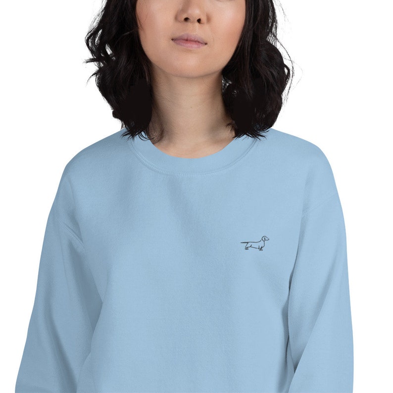 May include: A light blue sweatshirt with a small embroidered dachshund on the front.