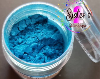 May include: A small jar of teal blue glitter with a clear lid. The jar is labeled "Sister's Glitter Shoppe".