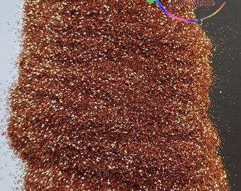 May include: A close-up of a pile of fine copper glitter. The glitter is a warm, metallic brown color with a slight shimmer.