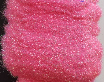 May include: Pink iridescent glitter with a fine texture. The glitter is shown in a pile on a white surface. The image includes the text "Sister's Glitter Shoppe".