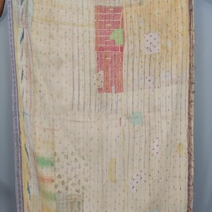 May include: A rectangular textile featuring a cream-colored base with vertical stripes and small diamond patterns. The fabric includes various patches in shades of red, yellow, green, and blue, with visible running stitch embroidery throughout the surface.