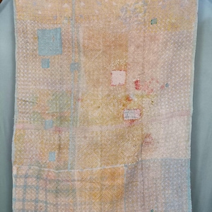 May include: A rectangular textile featuring a patchwork design with various geometric patterns in shades of pale yellow, light blue, and soft pink. The fabric displays intricate, dense running stitch embroidery throughout, creating a textured surface.