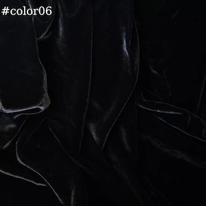 Puede incluir: Primer plano de tela de terciopelo negro con una textura suave y lisa. La tela est&aacute; doblada y drapeada, creando un aspecto lujoso y elegante.