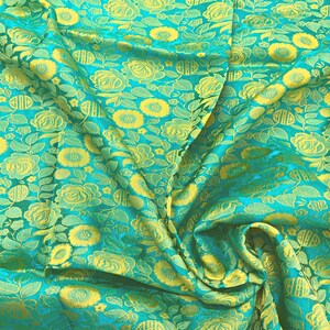 May include: Teal fabric with a yellow floral pattern. The fabric is woven with a raised texture, giving it a three-dimensional look.