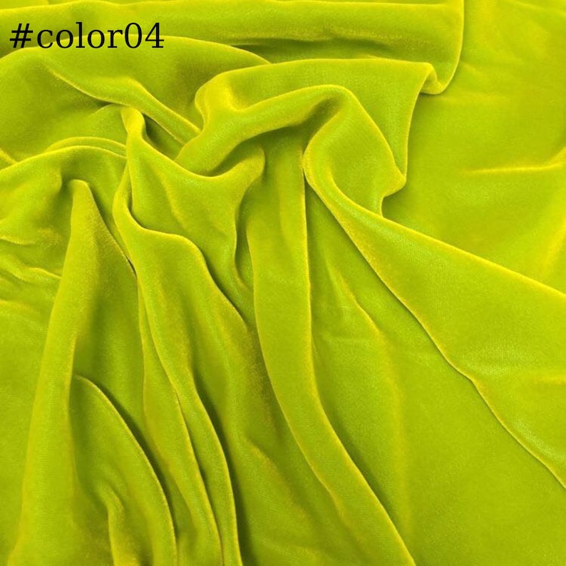 May include: A close-up of a bright green velvet fabric. The fabric is soft and smooth, with a subtle sheen. It is ideal for a variety of sewing projects, such as dresses, skirts, and jackets.