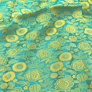 May include: Teal fabric with a yellow floral pattern. The fabric has a textured, woven look.