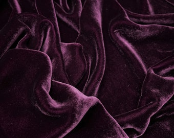 Könnte beinhalten: Nahaufnahme eines tiefvioletten Samtstoffes mit weichen, fließenden Falten und einer luxuriösen Textur.