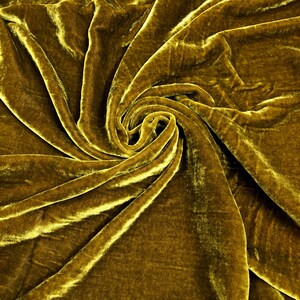 May include: A close-up of a luxurious, golden yellow velvet fabric. The fabric is draped and folded, creating a soft and elegant texture.