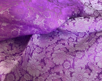 Pode incluir: Tecido roxo com um padrão floral branco. O tecido tem uma textura em relevo, o que lhe confere um efeito 3D.