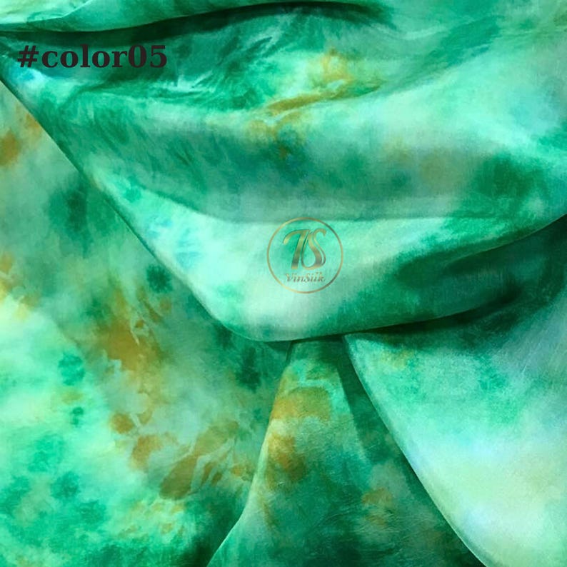 May include: Green and gold tie-dye fabric with a white background. The fabric is folded and has a subtle sheen. The text #color05 is visible in the top left corner of the image.