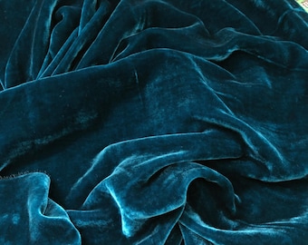 Könnte beinhalten: Nahaufnahme von tealfarbenem Samtstoff, der die weiche, plüschige Textur und die satte Farbe zeigt.