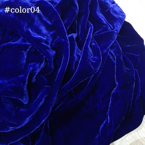 Puede incluir: Primer plano de una tela de terciopelo azul oscuro, que muestra la textura y el drapeado del material.