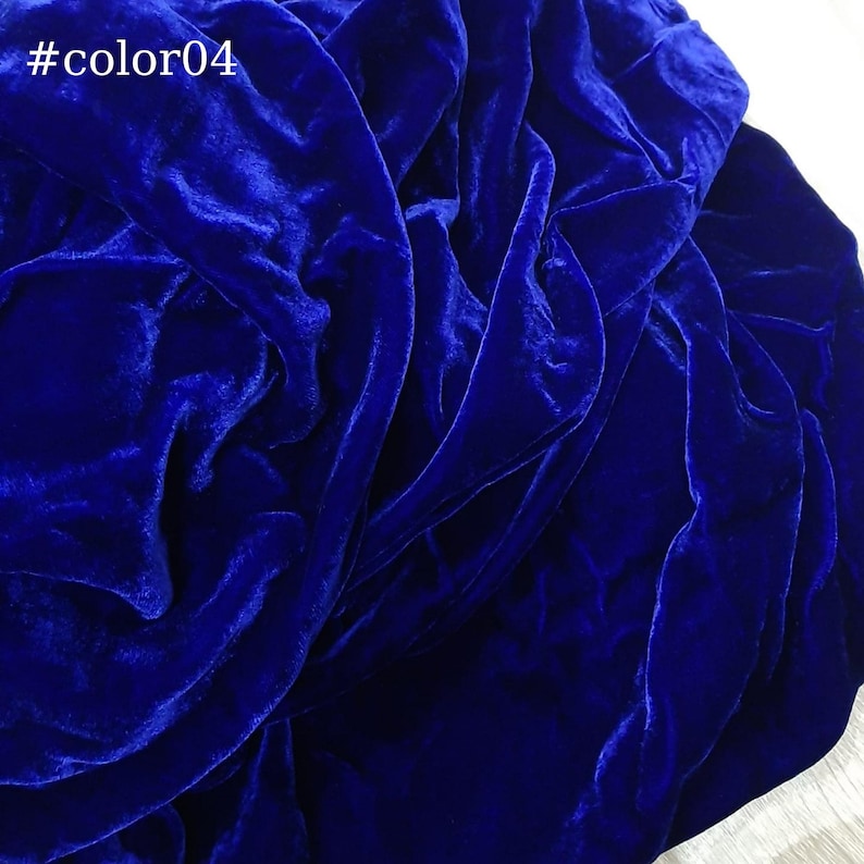 Puede incluir: Primer plano de una tela de terciopelo azul oscuro, que muestra la textura y el drapeado del material.
