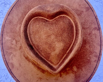 May include: A brown suede hat with a heart-shaped indentation in the crown.