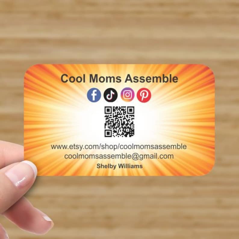 Puede incluir: Una tarjeta de visita con un fondo naranja y amarillo brillante que presenta el texto "Cool Moms Assemble" y un c&oacute;digo QR. Se incluyen iconos de redes sociales para Facebook, TikTok, Instagram y Pinterest. La tarjeta tambi&eacute;n incluye la direcci&oacute;n del sitio web "www.etsy.com/shop/coolmomsassemble" y la direcci&oacute;n de correo electr&oacute;nico "coolmomsassemble@gmail.com". La tarjeta est&aacute; firmada por "Shelby Williams".