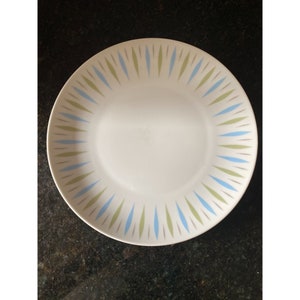 Peut inclure: Une assiette en céramique blanche avec un motif géométrique bleu et vert autour du bord.