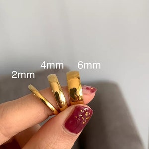 May include: Four gold rings of different widths, labelled 2mm, 4mm, and 6mm. The rings are stacked on top of each other, with the largest ring at the bottom.